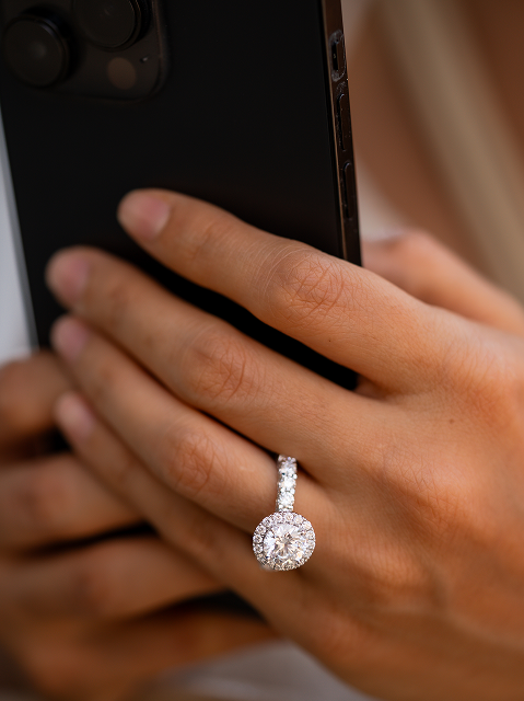 Diamond ring on finger while holding an iPhone